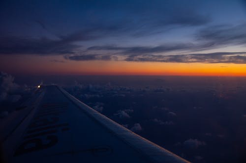 在蓝蓝的天空下的天空上飞翔的飞机机翼 · 免费素材图片