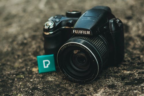 黑色fujifilm Dsrl相机在地面上的特写照片 · 免费素材图片