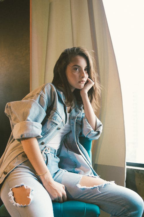 坐在窗户旁边的女人的照片 · 免费素材图片