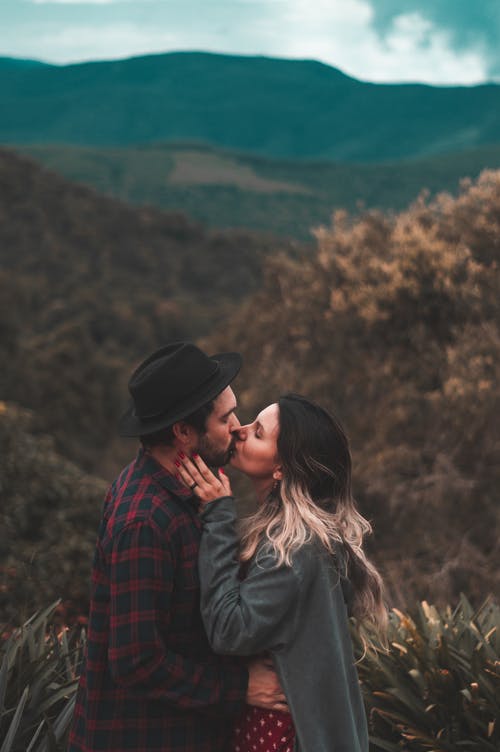 男人和女人在棕色树附近接吻 · 免费素材图片