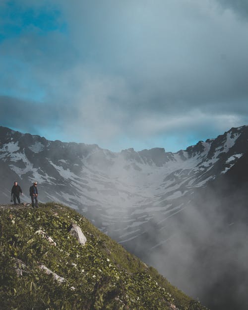 雪山附近山上的两个男人 · 免费素材图片