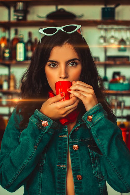 女人从红色咖啡杯子喝的特写照片 · 免费素材图片