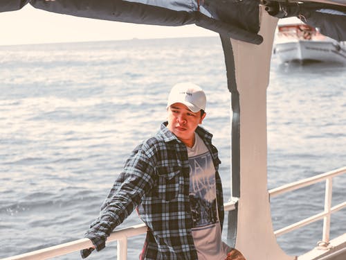 男子站在船上的照片 · 免费素材图片