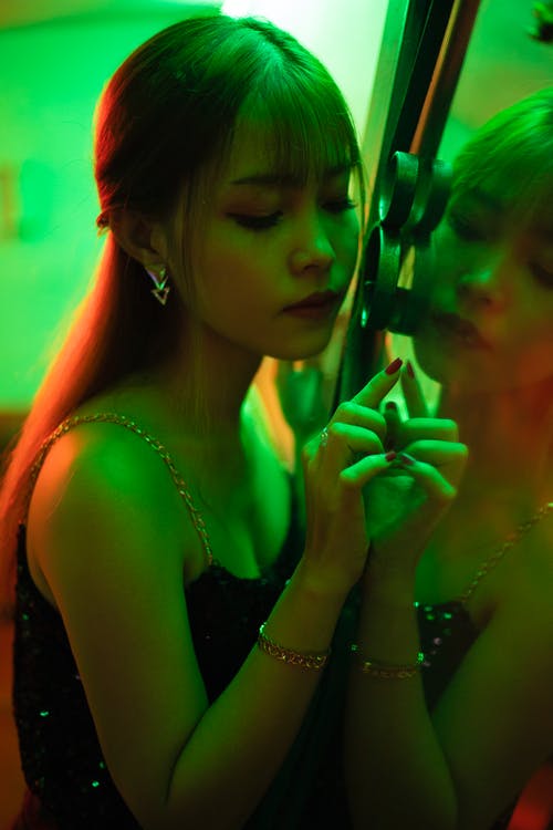 靠在镜子上的女人的照片 · 免费素材图片