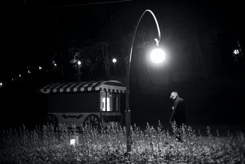 男子站在灯柱下 · 免费素材图片