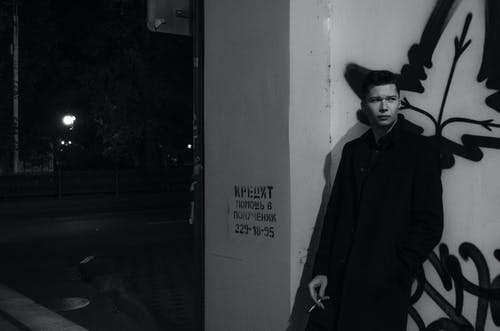 男子倚在墙上 · 免费素材图片