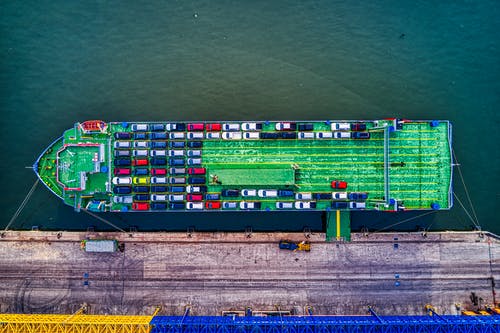 码头旁边的绿色货船 · 免费素材图片