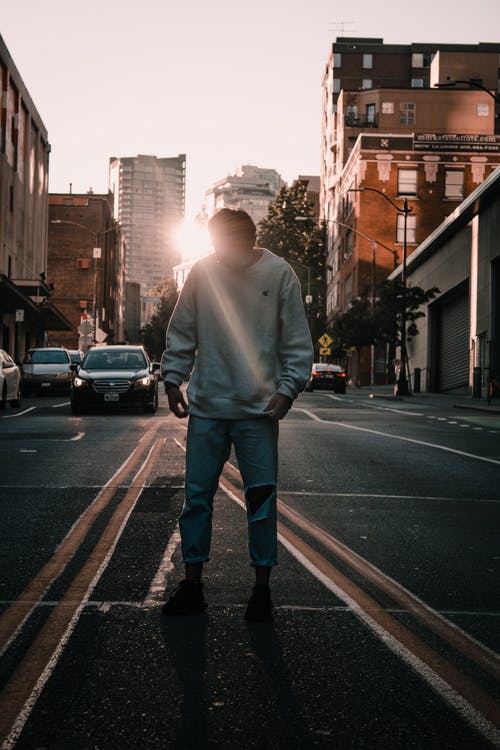 穿白色毛衣和灰色牛仔牛仔裤的男人 · 免费素材图片