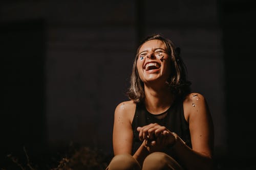 一个女人笑着穿着黑色上衣的照片 · 免费素材图片