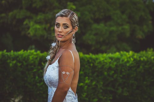 一个女人站在绿色的植物附近的照片 · 免费素材图片