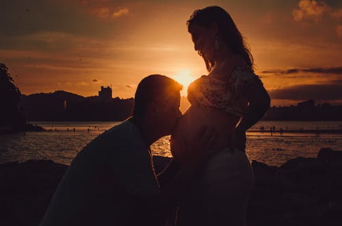 男人亲吻孕妇的肚子的剪影摄影 · 免费素材图片