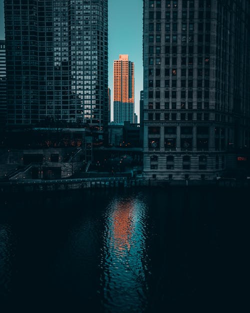 水体旁的灰色高层建筑 · 免费素材图片