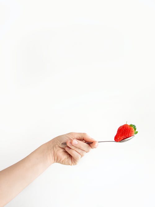 人控股勺子与草莓 · 免费素材图片