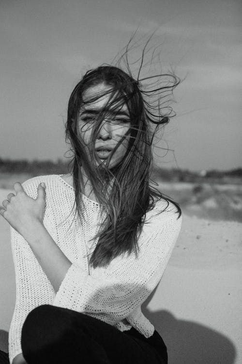 白色针织毛衫坐的女人 · 免费素材图片