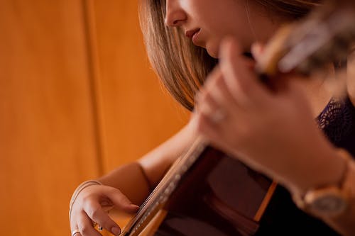 女人弹吉他的选择性焦点照片 · 免费素材图片