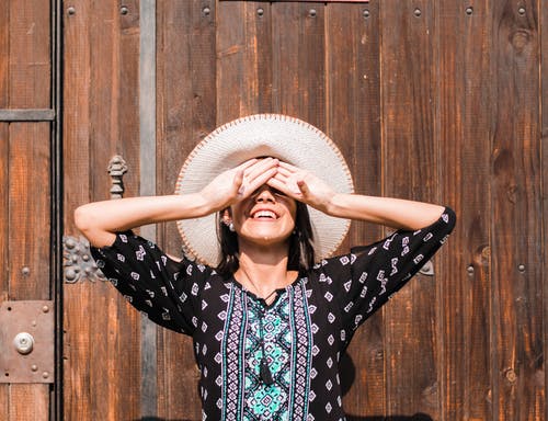 站在棕色墙旁边的女人 · 免费素材图片