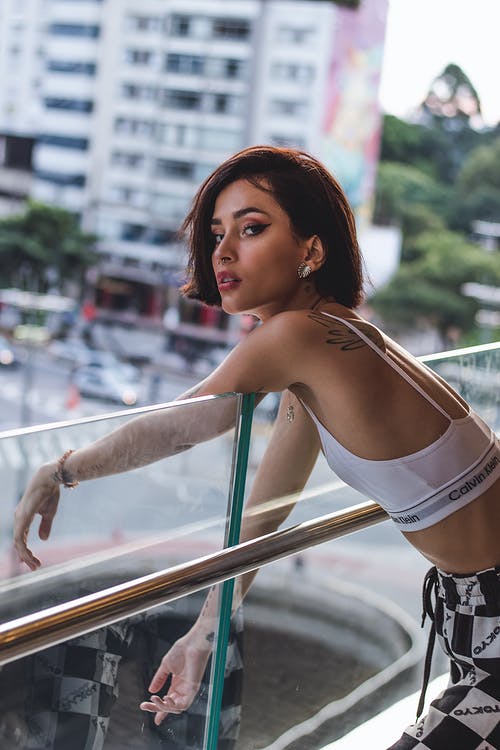 倚在透明玻璃栏杆上的女人 · 免费素材图片