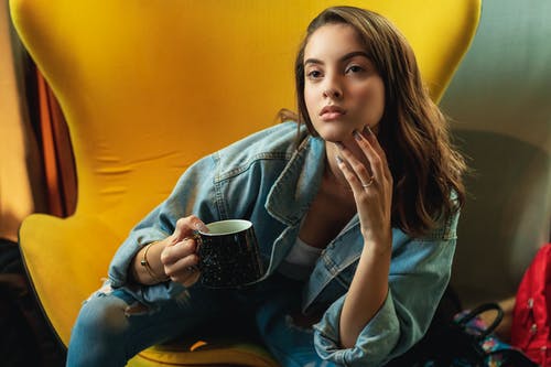 一个女人坐在一个黑色的陶瓷杯子里坐着的照片 · 免费素材图片