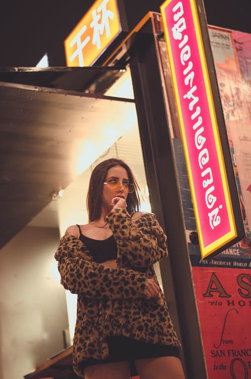 穿黑色和棕色豹纹外套的女人 · 免费素材图片