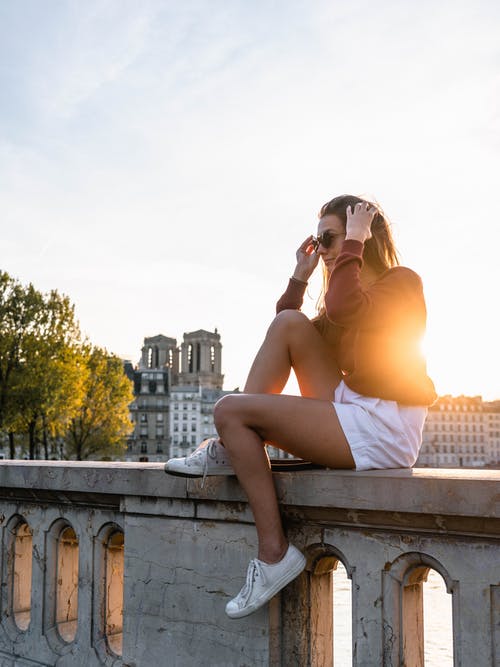 女人在日落时坐在混凝土ball · 免费素材图片