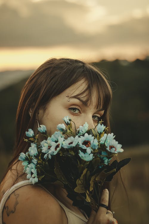 女人在焦点摄影上捧着花 · 免费素材图片