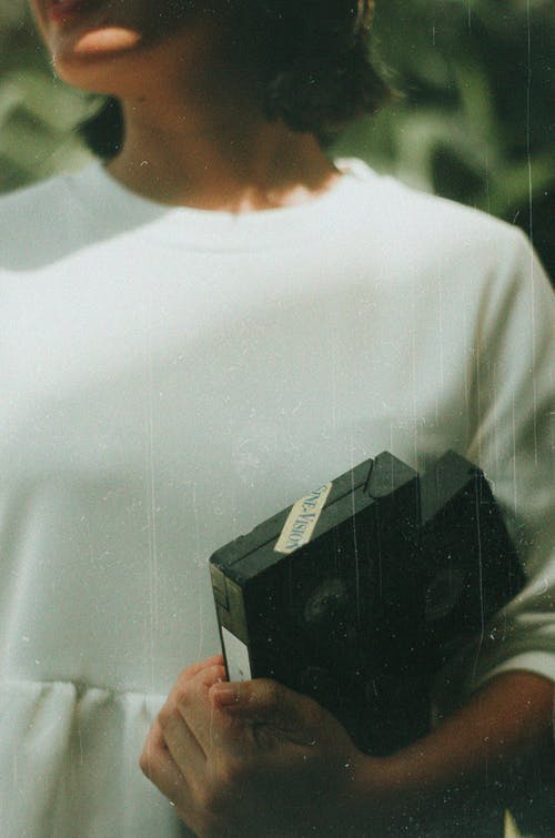 女人抱着黑色vhs磁带 · 免费素材图片