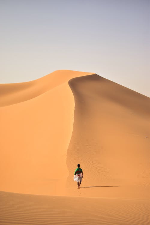 在沙漠上行走的人 · 免费素材图片