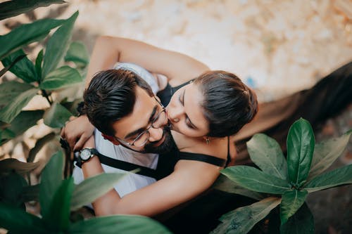 黑背心接吻穿着绿色衬衫的男人的女人 · 免费素材图片