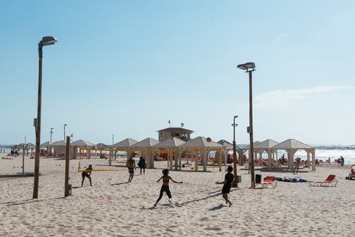 在湛蓝的天空下打沙滩排球的人 · 免费素材图片