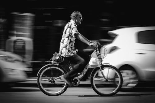 公路自行车上的人骑自行车的灰度照片 · 免费素材图片
