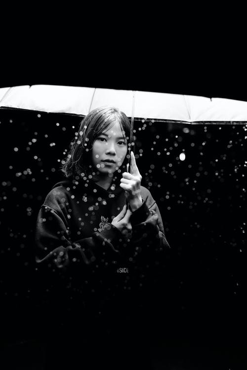 女人拿着伞的灰度摄影 · 免费素材图片