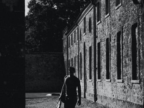 走在混凝土墙旁边的人 · 免费素材图片