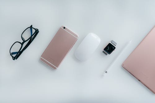 魔术鼠标旁边的金色iphone 6 · 免费素材图片