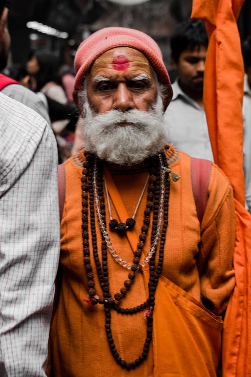 橙色衣服的人在额头上有红色标记 · 免费素材图片