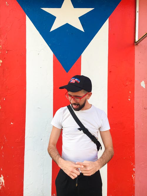 男子站在波多黎各国旗附近 · 免费素材图片