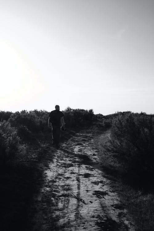 在土路上行走的人的单色照片 · 免费素材图片
