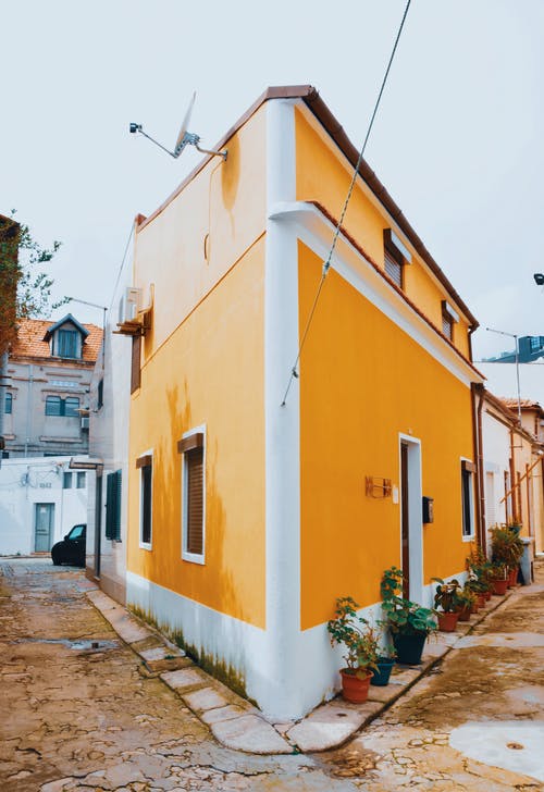 黄色和白色混凝土路边的房子 · 免费素材图片