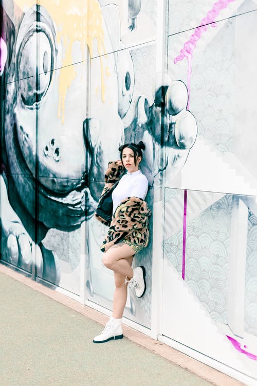 女人站在墙上的摄影 · 免费素材图片