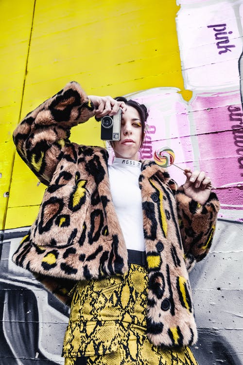 女人拿着黑色的相机 · 免费素材图片