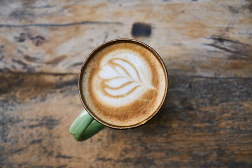 拿铁咖啡在绿色杯子上的高角度摄影 · 免费素材图片