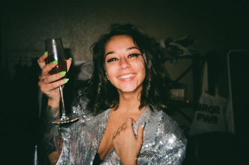 举起香槟杯与饮料的微笑妇女的肖像照片 · 免费素材图片