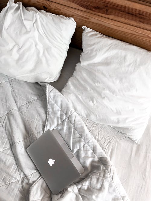 Macbook在凌乱的床上 · 免费素材图片