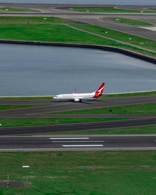 白色和红色飞机在跑道上 · 免费素材图片