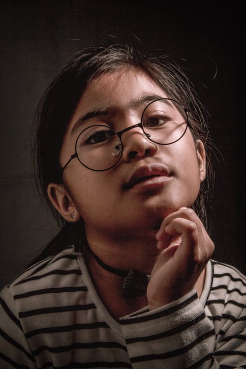 黑色和白色条纹毛衣，配黑色镜框眼镜的女孩的肖像照片 · 免费素材图片