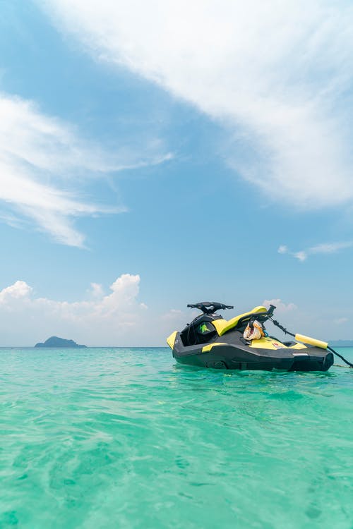 在青色海水中空黄色和黑色摩托艇 · 免费素材图片