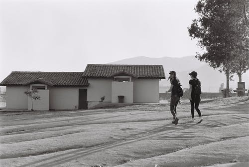 两个女人走在房子附近 · 免费素材图片