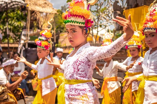 身穿黄色和白色传统服饰并跳舞的儿童 · 免费素材图片