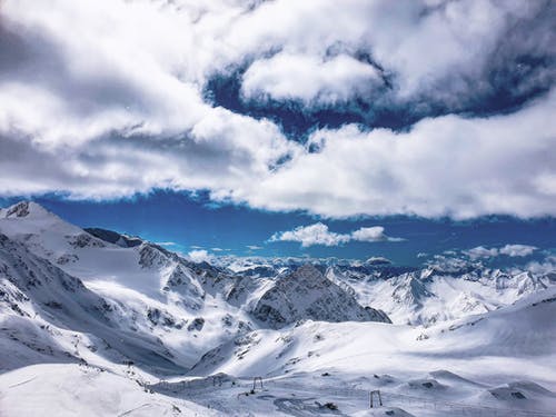 白云盘旋在雪山坡度假村上方 · 免费素材图片