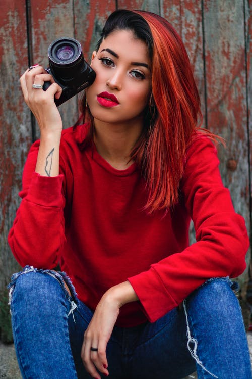 坐在地上拿照相机的女人的照片 · 免费素材图片