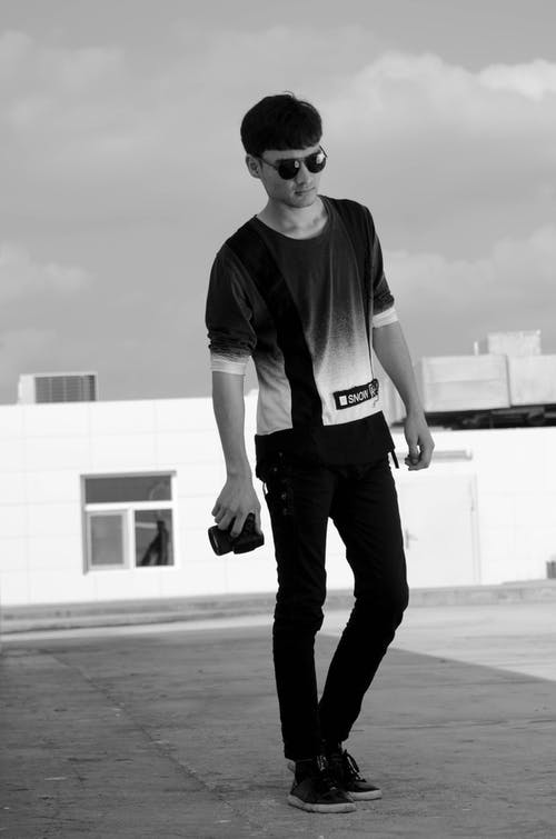 灰度照片og男子手持单反相机 · 免费素材图片